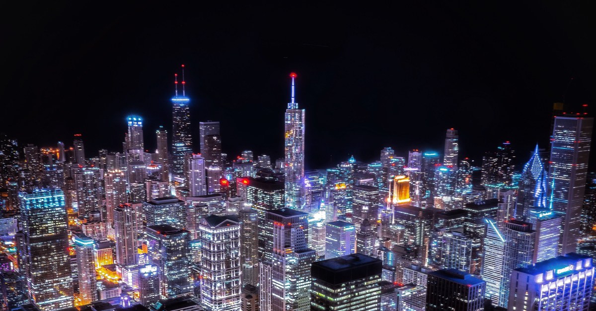 Aerial night view of a city with its grid of buildings and streets fully lit, power reaching every block.